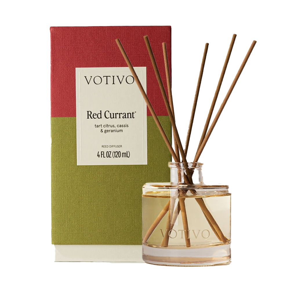 Votivo Red Currant reed diffuser with a clear glass bottle, brown reeds, and a green and red box packaging.