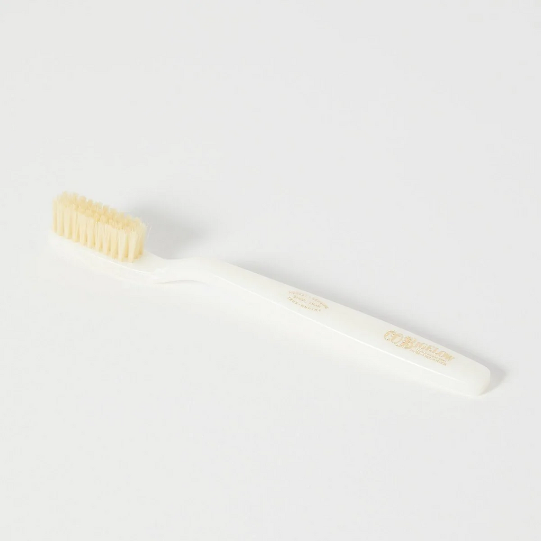 A white toothbrush with pale fiber bristles