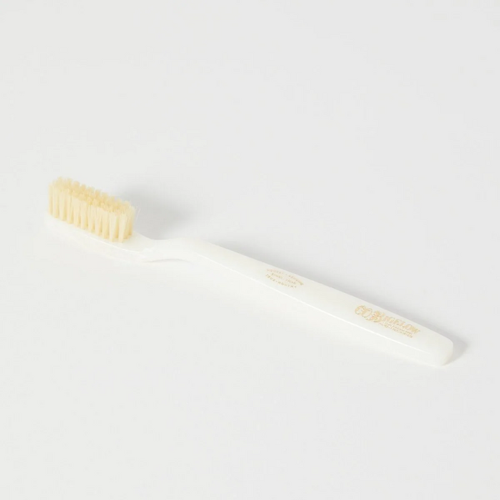 A white toothbrush with pale fiber bristles