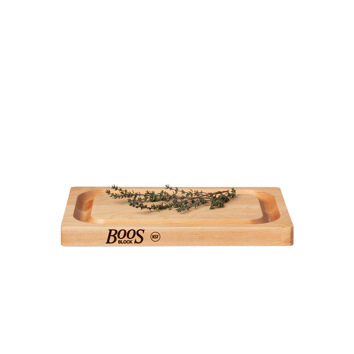 A wooden cutting board with juice grooves