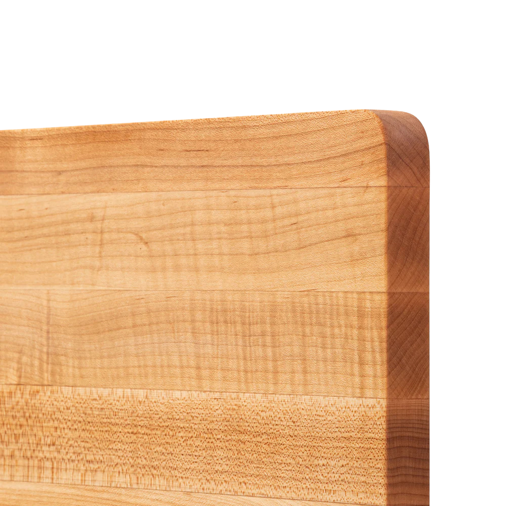 Close-up of a wooden cutting board with a light brown color and visible grain pattern.