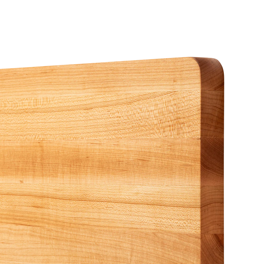 Close-up of a wooden cutting board with a light brown color and visible grain pattern.