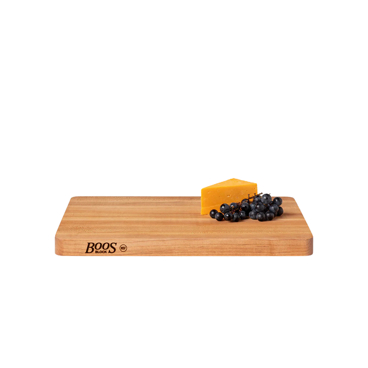 Wooden cutting board with a block of cheese and grapes 