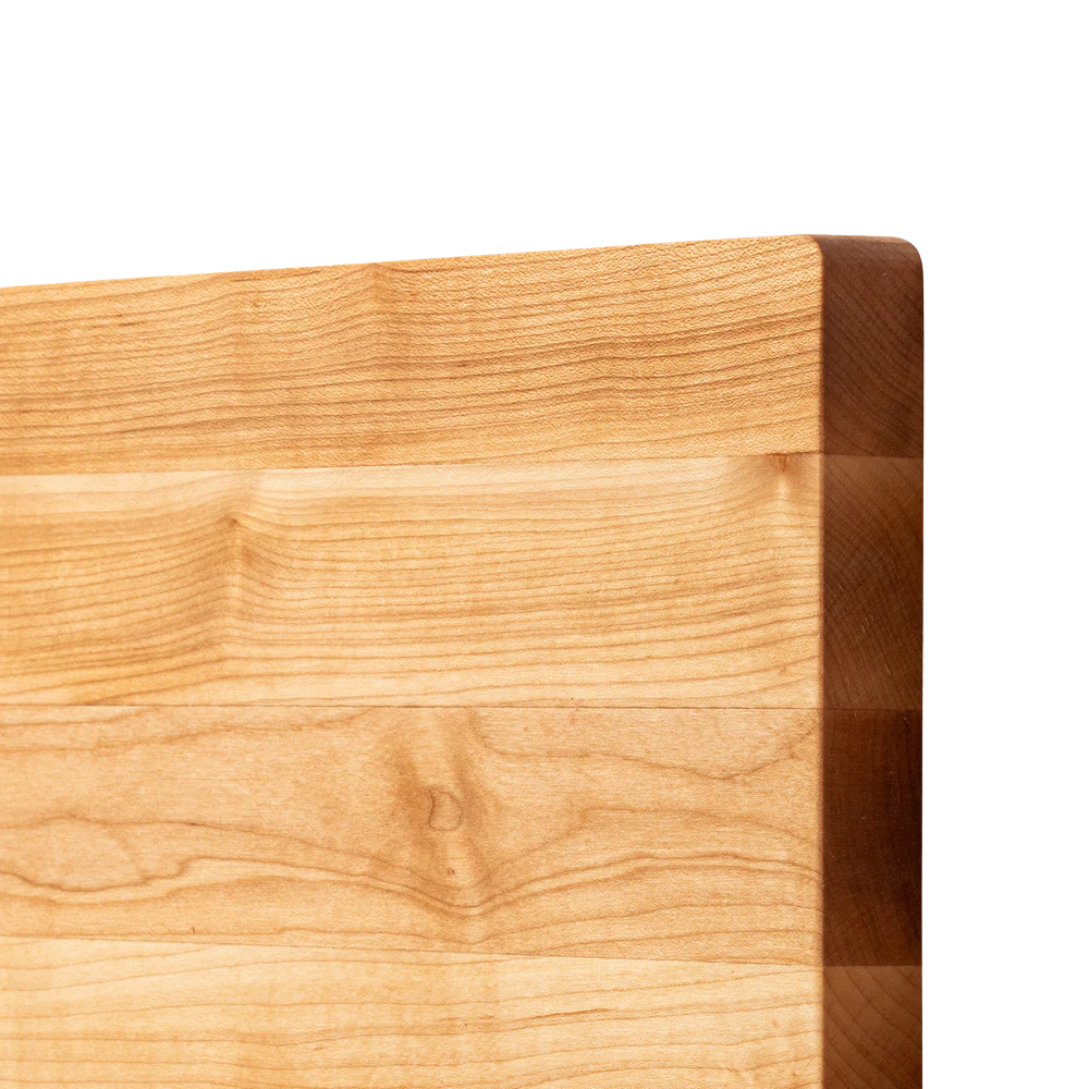 Close-up of a wooden cutting board with a light brown color and visible grain pattern.