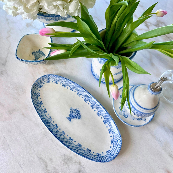 Decorative blue and white ceramic items on a marble surface with flowers.