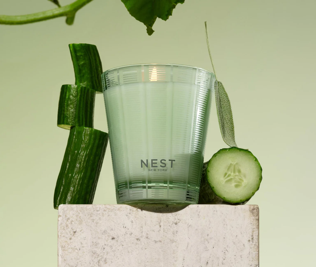 NEST cucumber and white sage candle with cucumbers on a light green background