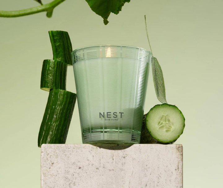 NEST cucumber and white sage candle with cucumbers on a light green background