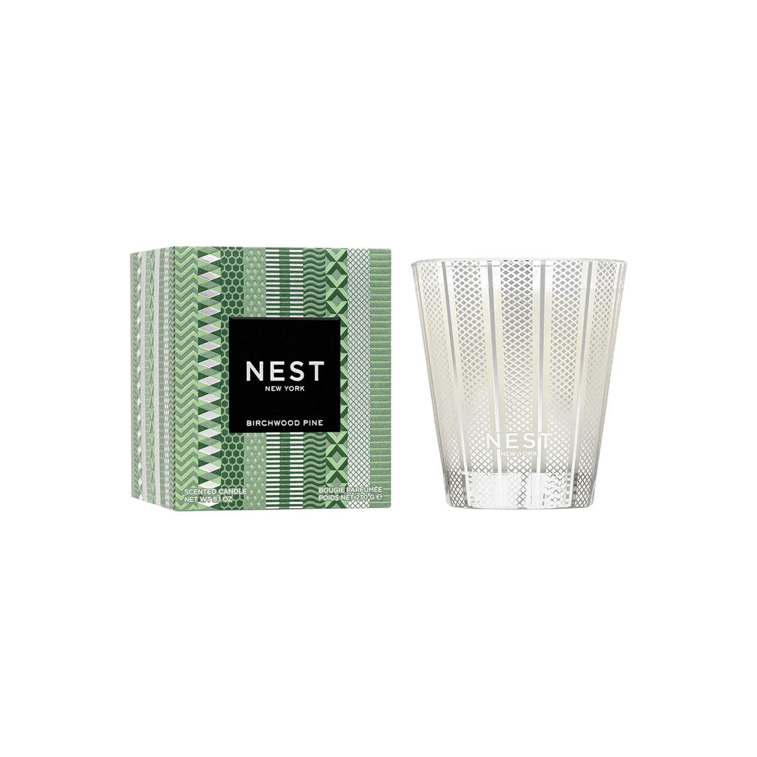 Nest birchwood pine candle in a clear holder with packaging on a white background