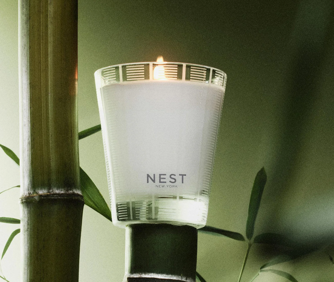 Nest bamboo classic candle in a natural setting with bamboo and leaves.