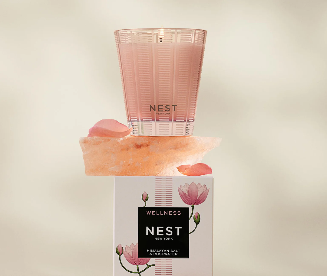 Nest Himalayan Salt and rosewater classic candle on top of a salt rock on the candle packaging
