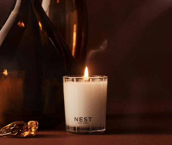 Nest Moroccan Amber candle lit next to a piece of amber