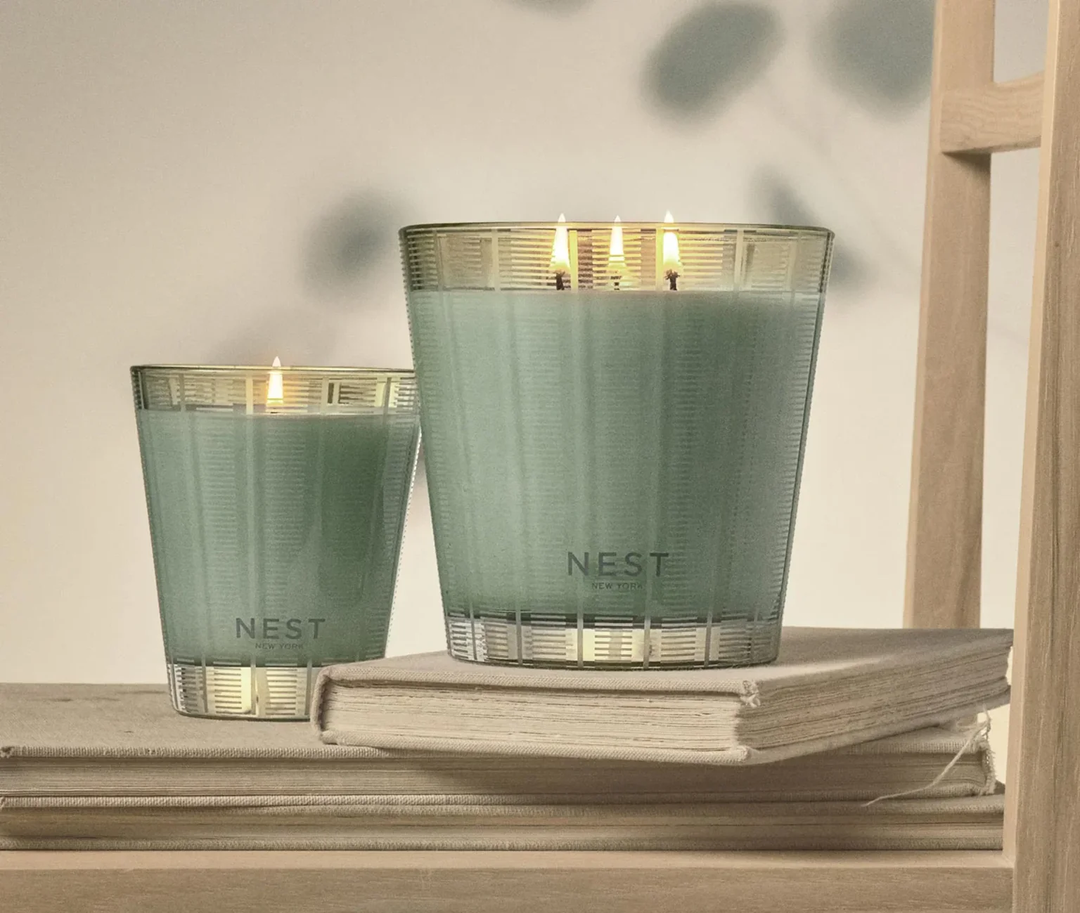 Two Wild Mint and Eucalyptus NEST candles on a wooden chair 