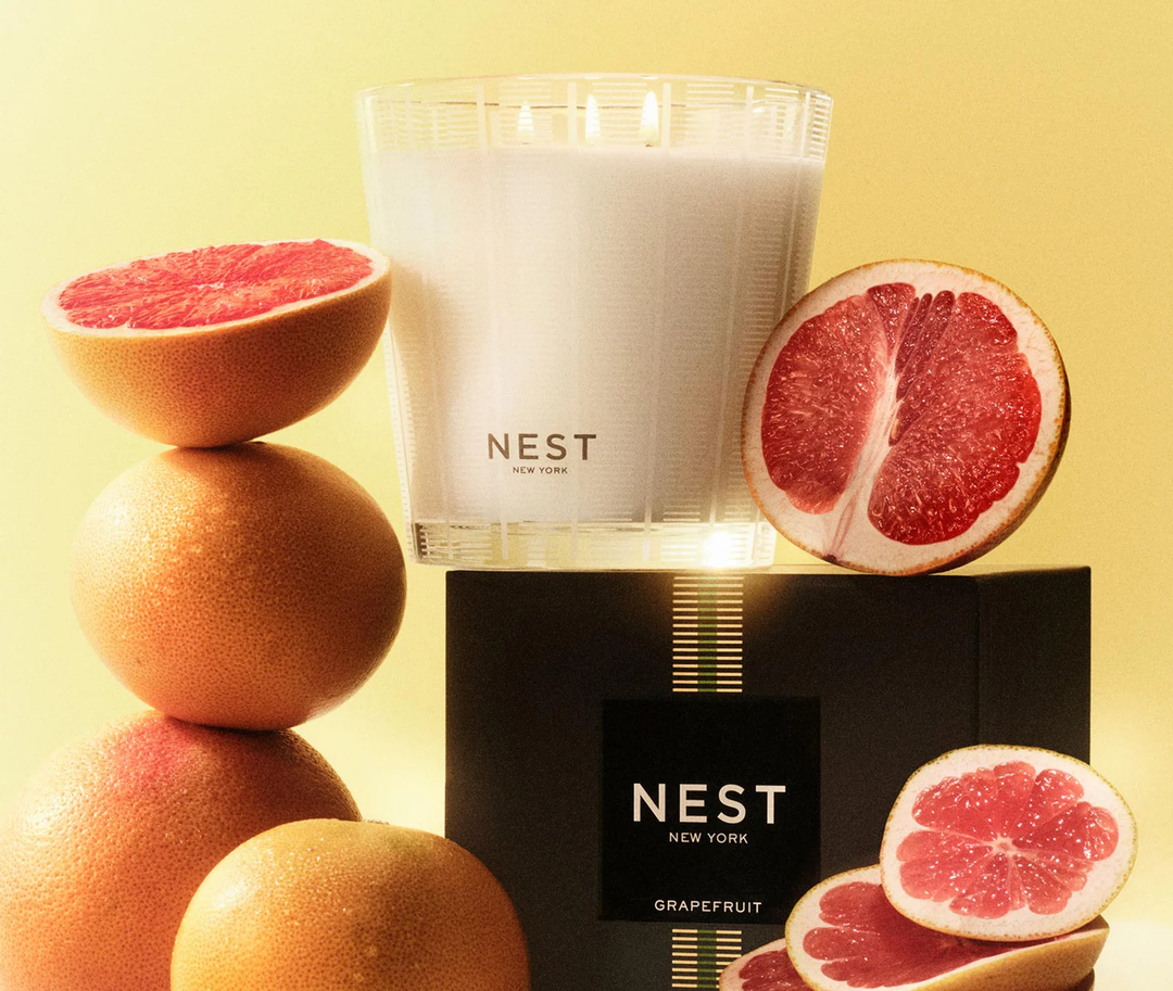NEST New York grapefruit candle with sliced grapefruits on a yellow background
