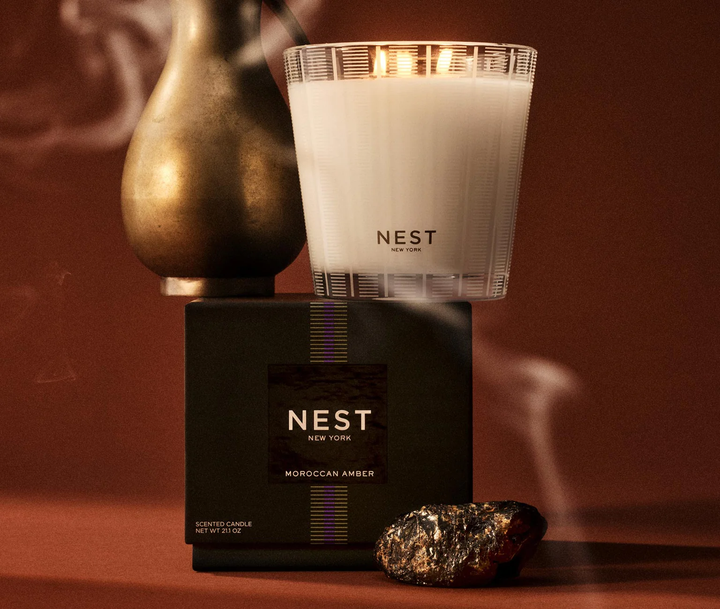 NEST New York Moroccan Amber candle and packaging on a warm brown background