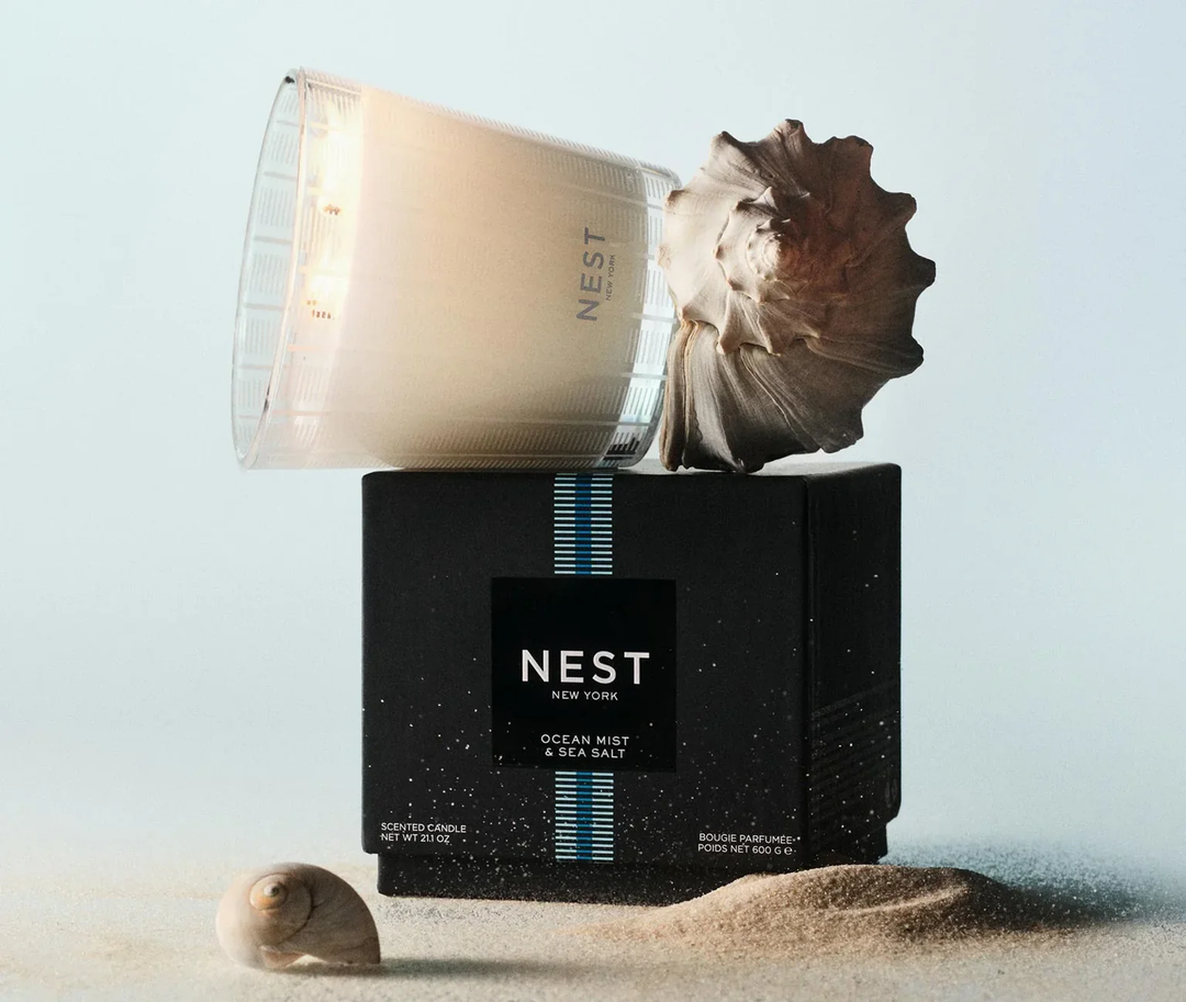 NEST Ocean Mist and Sea Salt candle with a shell on top of its packaging 