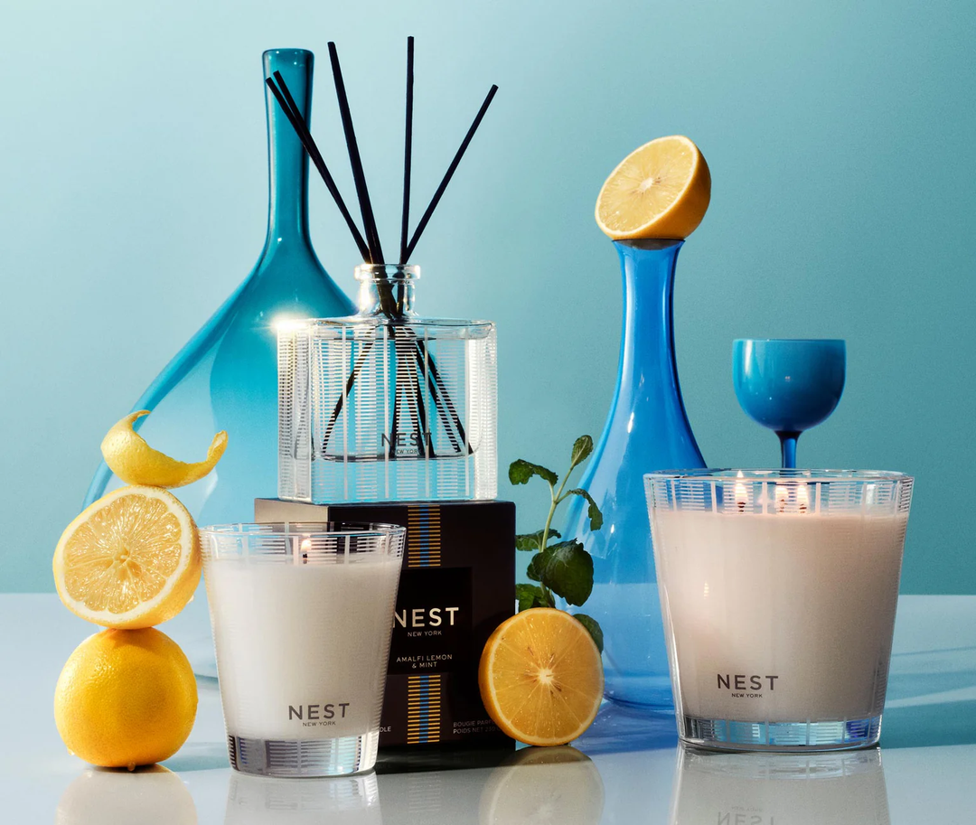 Nest classic and three wick candles with decorative lemons, mint, and blue vases