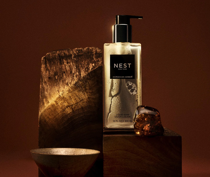 NEST moroccan amber liquid soap bottle on a wooden surface with a warm brown background
