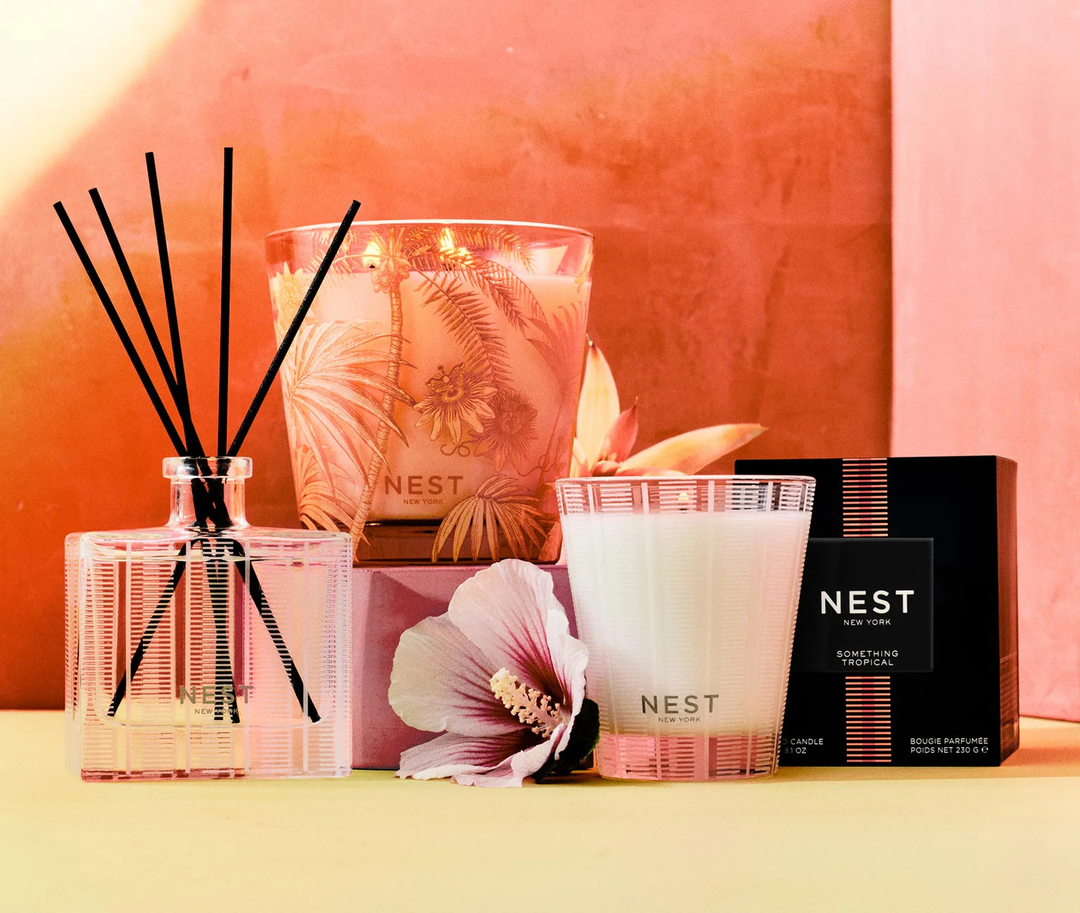 NEST New York classic and decorative Something Tropical candles and reed diffuser set with a roase of sharon flower against a pink background