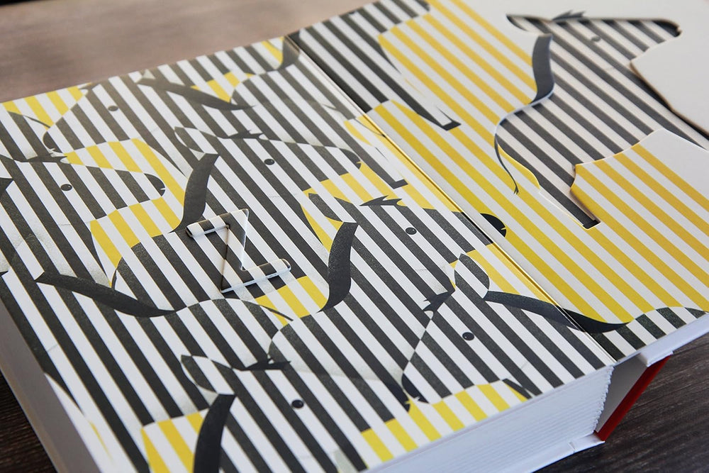 Patterned paper with black, white, and yellow design on a wooden surface
