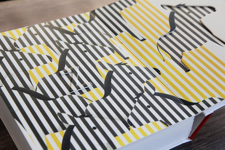 Patterned paper with black, white, and yellow design on a wooden surface