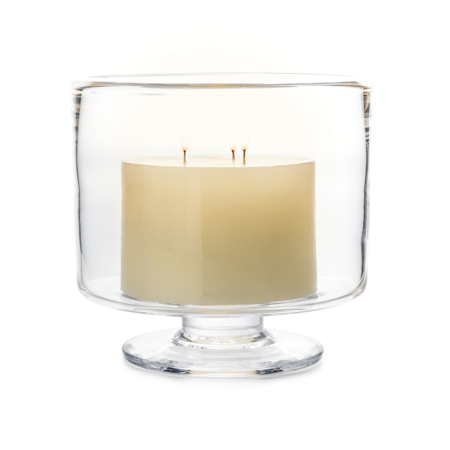 Clear glass footed candle holder with a beige candle