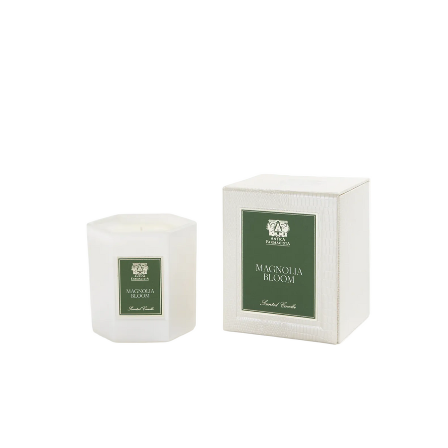 White candle with 'Magnolia Bloom' label next to its packaging