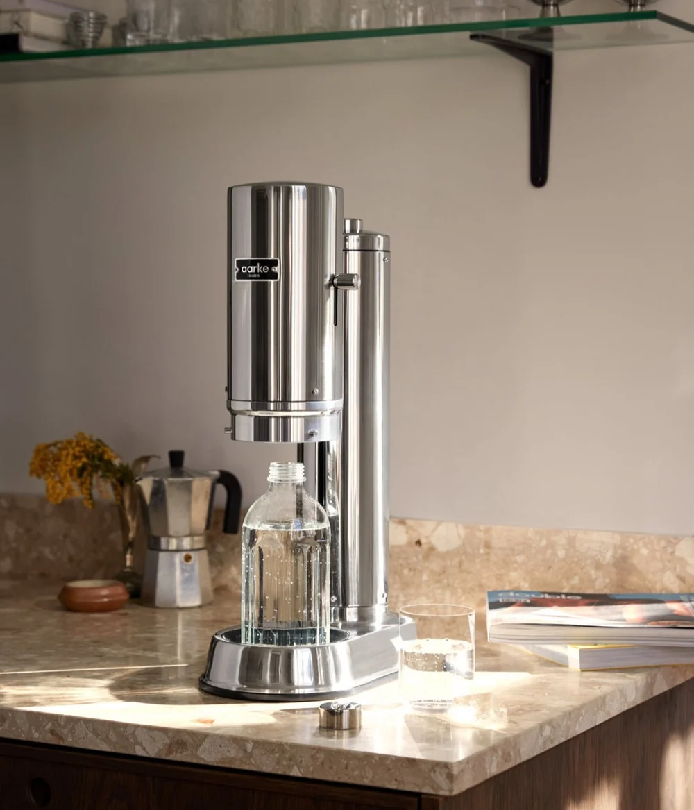 Stainless steel water filter on a kitchen counter with a blurred background