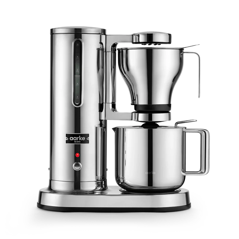 A sleek, professional drip coffee maker in polished stainless steel, featuring a tall water reservoir, a conical filter basket, and a large carafe on a white background.