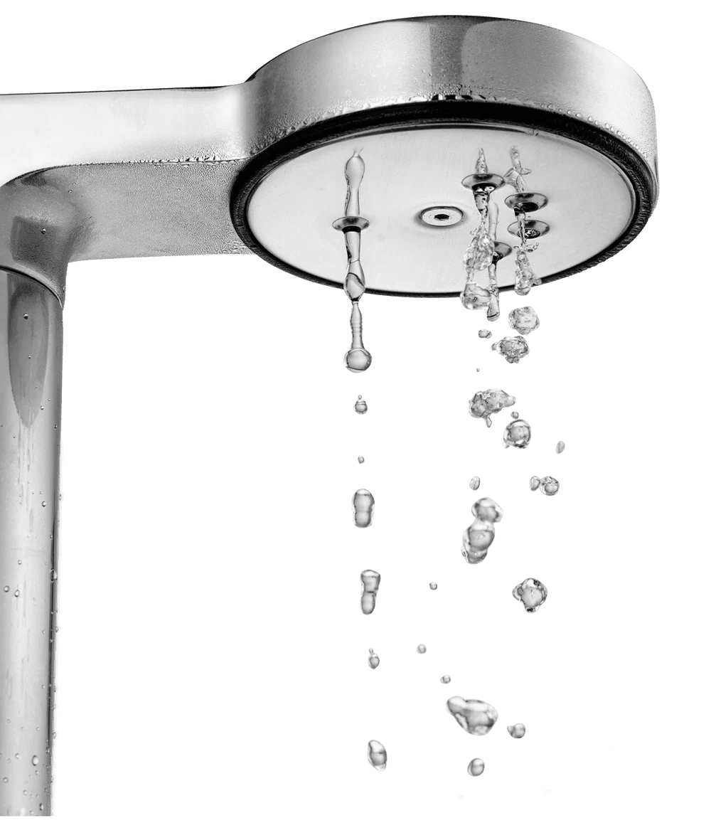 A close-up studio shot of a polished chrome shower head with water dripping from it against a plain white background.