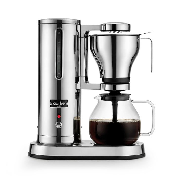 A sleek aarke coffee maker with a polished stainless steel body, a clear glass carafe containing dark coffee, and a matching glass dripper, shown on a clean white background.