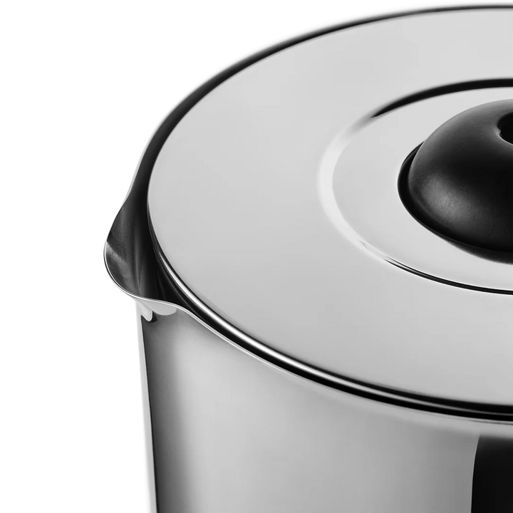 Close-up of a stainless steel electric kettle showing the polished metal body, rim, and lid with a black central knob against a white background.