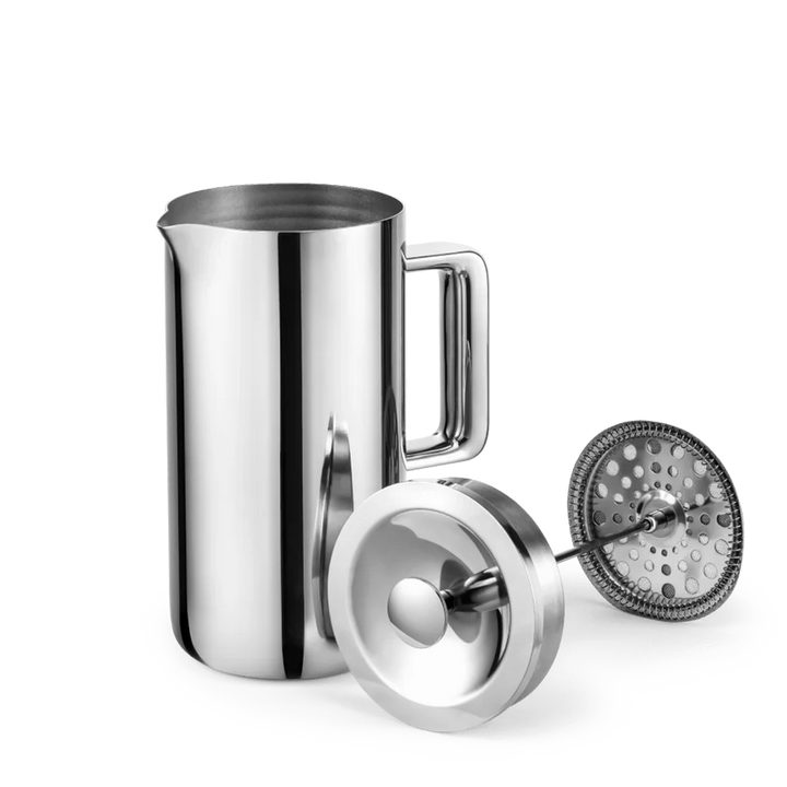 A stainless steel milk frother pitcher with a handle, shown with its lid and frothing insert on a clean white background.