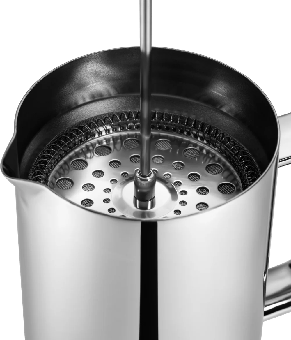 Close-up of a stainless steel milk frothing pitcher with a whisk attachment.