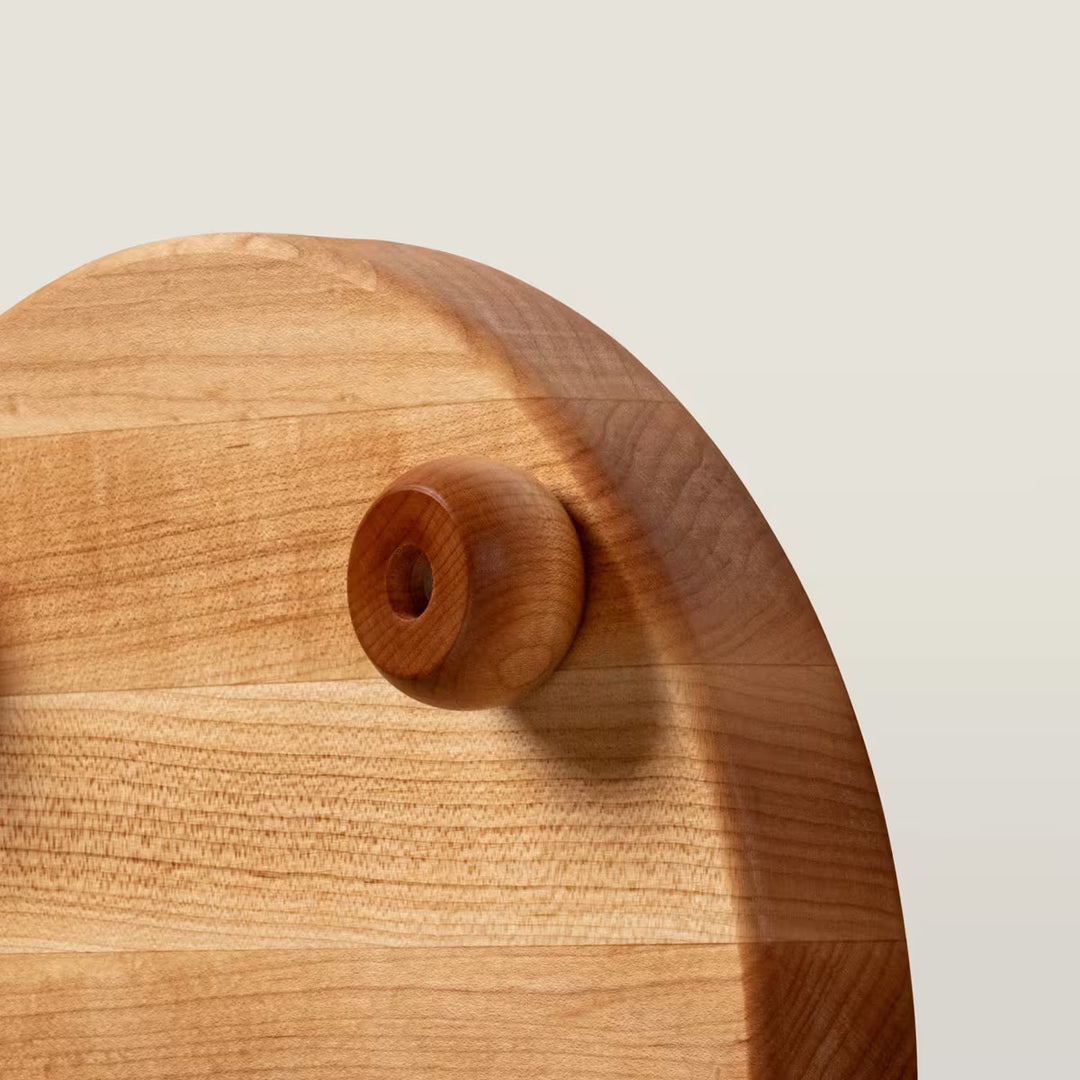 Wooden cutting board with a handle on a light beige background