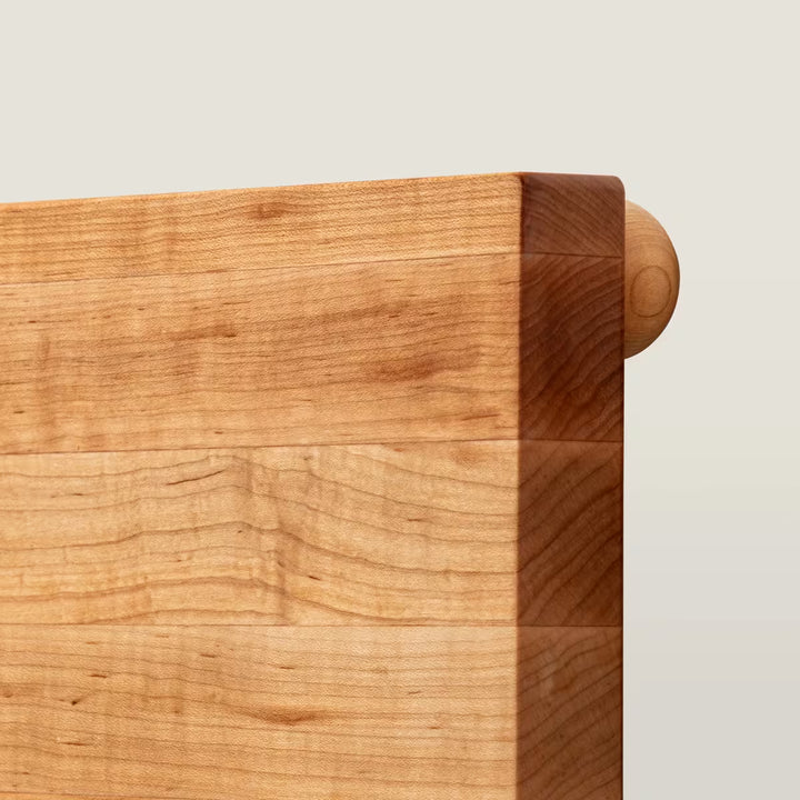 Close-up of a wooden headboard corner with a light background