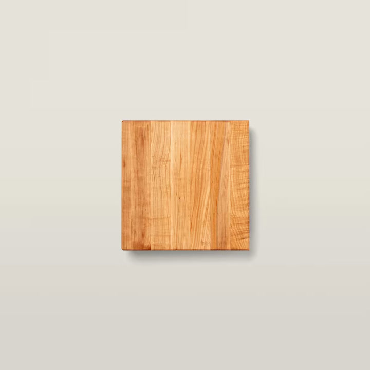 A square wooden board with a warm honey-brown wood grain finish, centered on a light beige background.