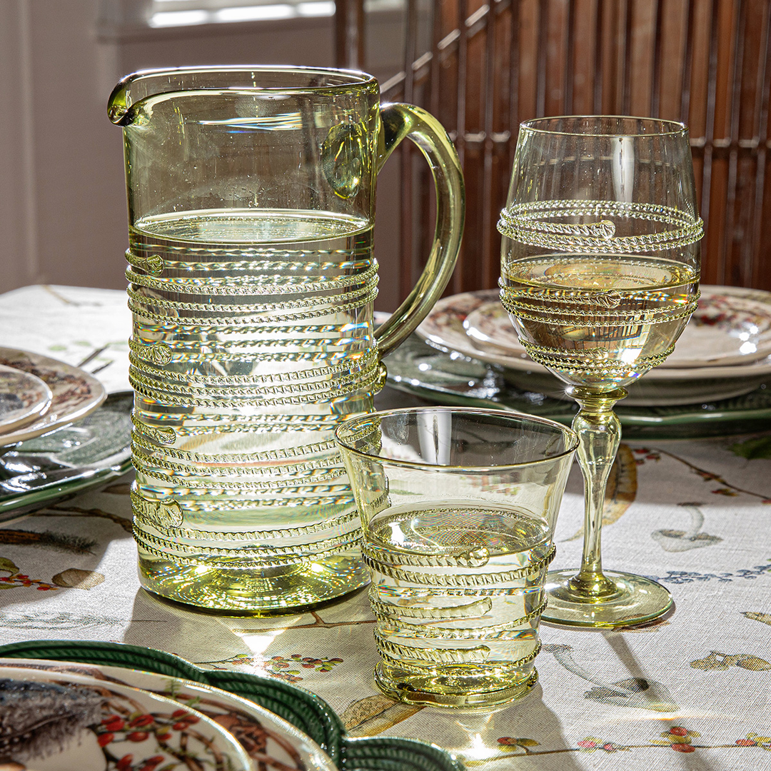 Clear glass pitcher and glasses on a patterned tablecloth