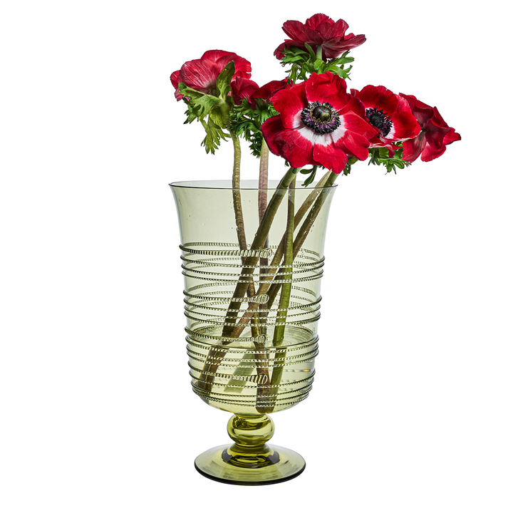 Green ribbed vase with red flowers on a white background