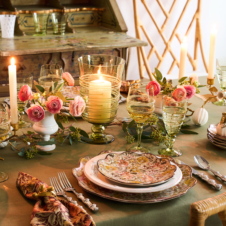 Elegant table setting with floral arrangements, candles, and glassware.