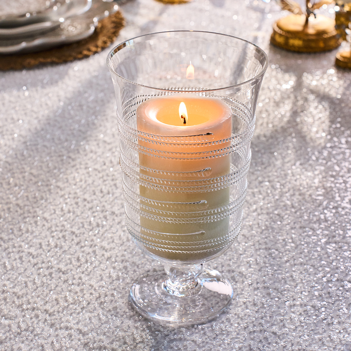 Decorative glass with a candle on a textured surface