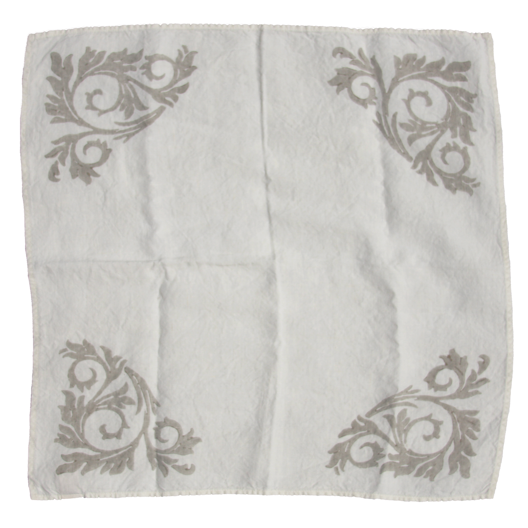 white linen napkin with slate grey designs on corners