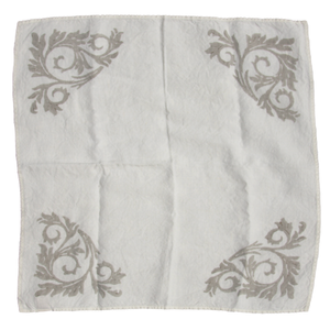 white linen napkin with slate grey designs on corners