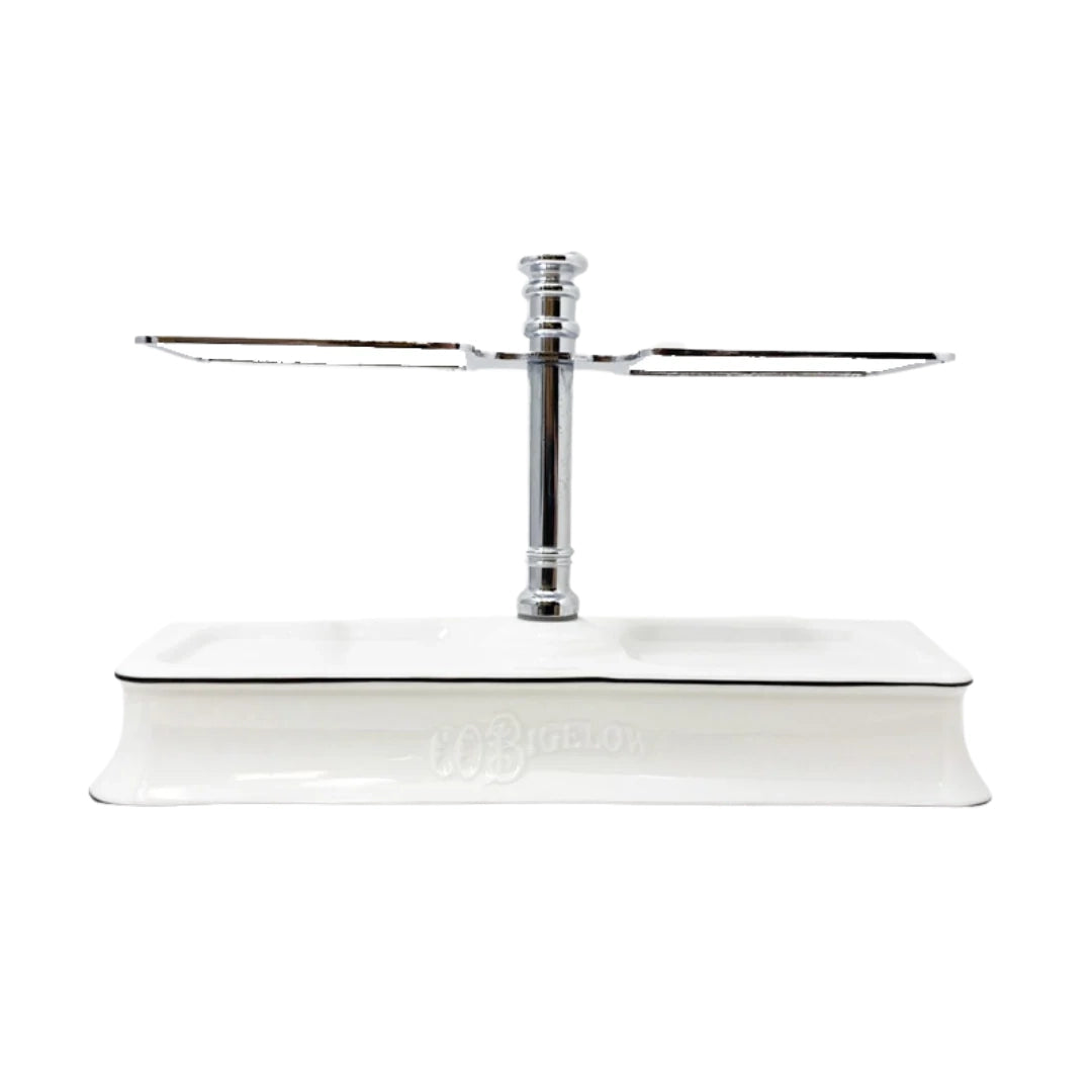 A white ceramic and stainless steel bottle stand for C O Bigelow soaps and lotions