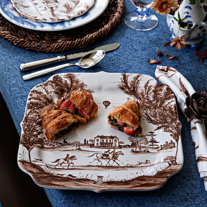 Decorative plate with a vintage design featuring food on a table setting.