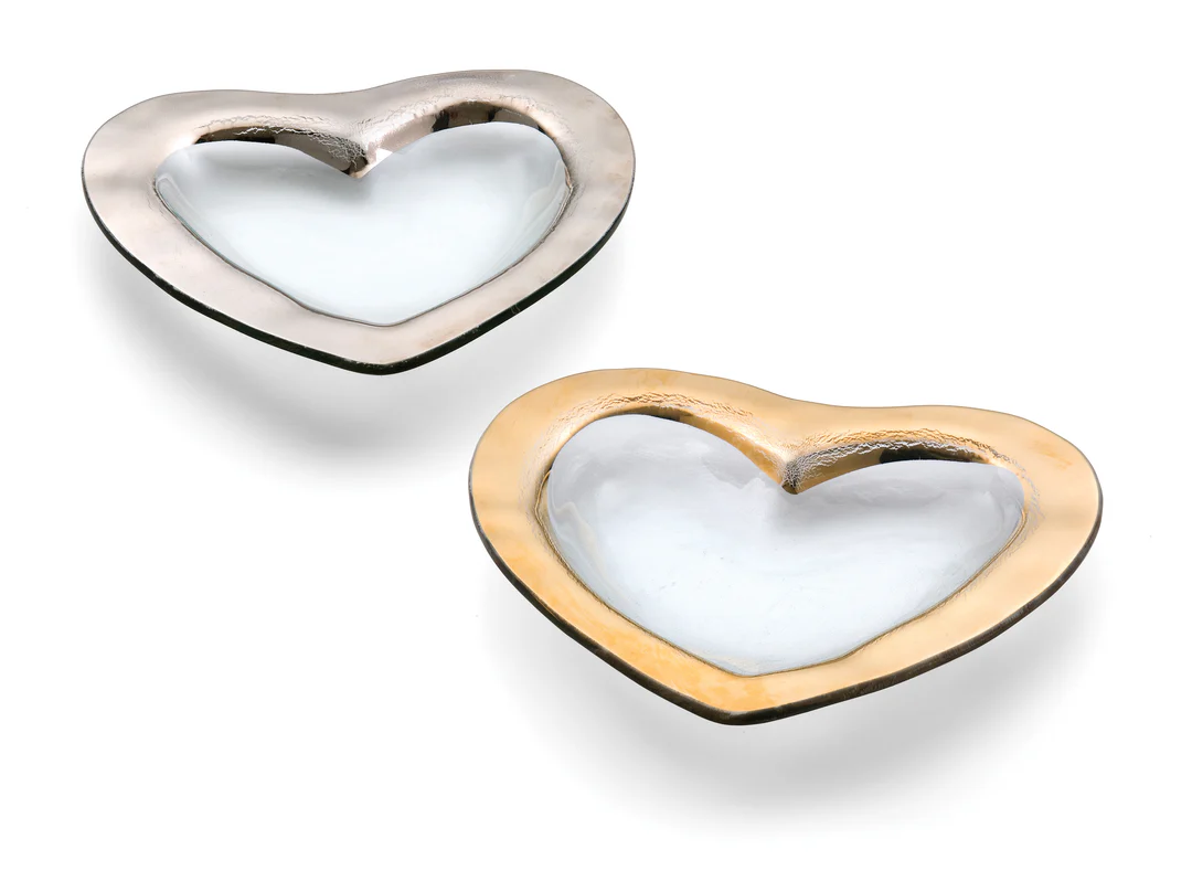 Two clear glass heart shaped bowls, one with a gold edge and the other silver