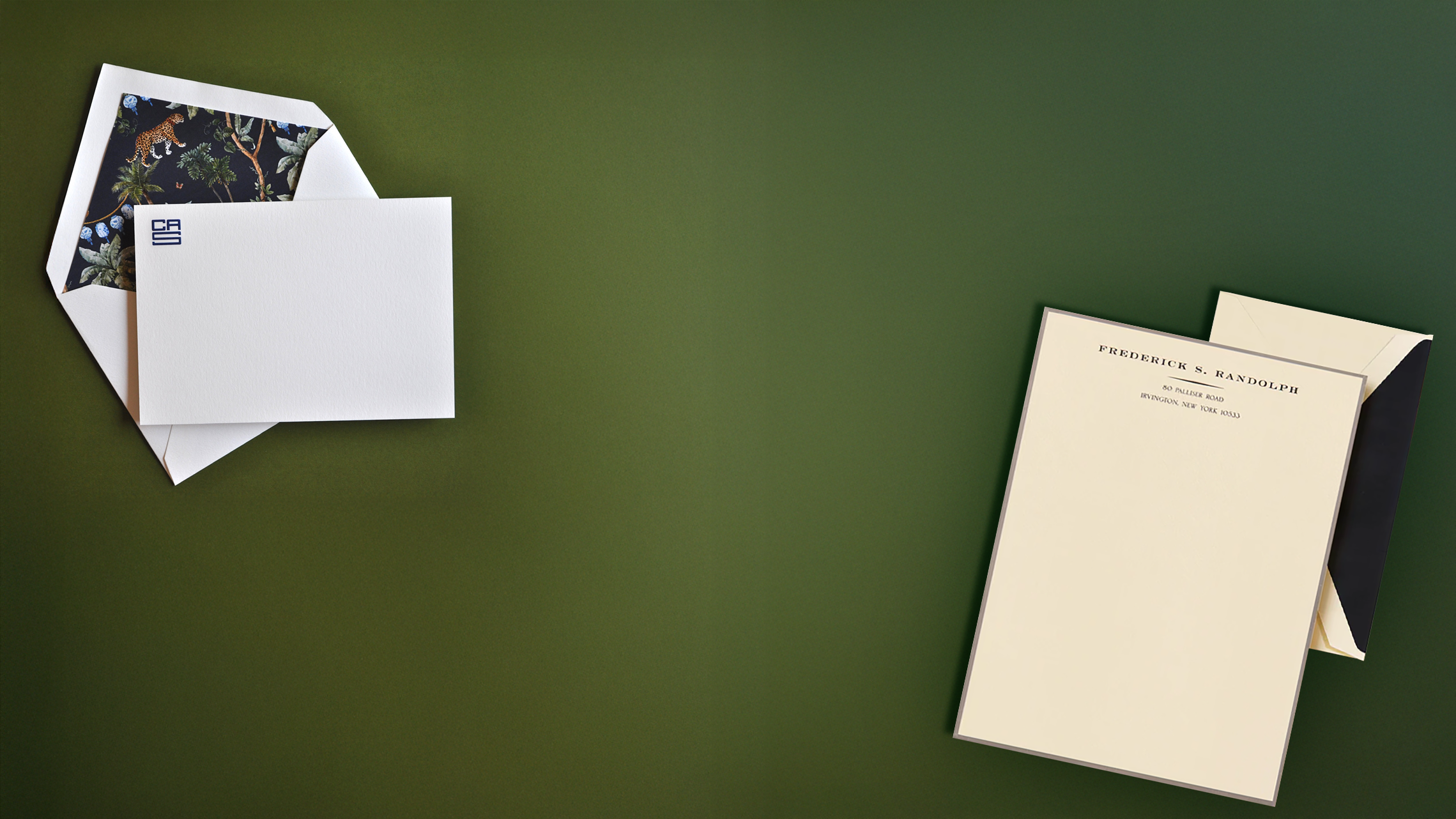 A white monogrammed card with a navy blue jungle envelope liner and an ecur off white letter sheet with a name engraved at the top