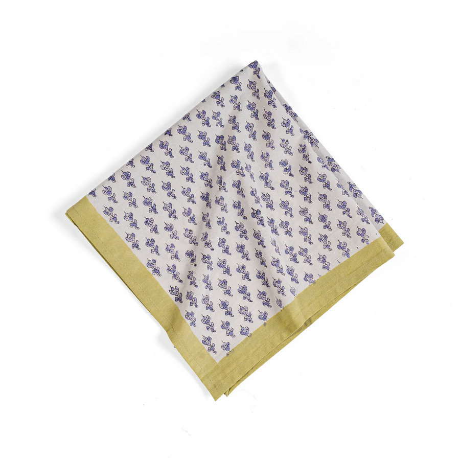 A white linen wiht a purple flower pattern and yellow trim