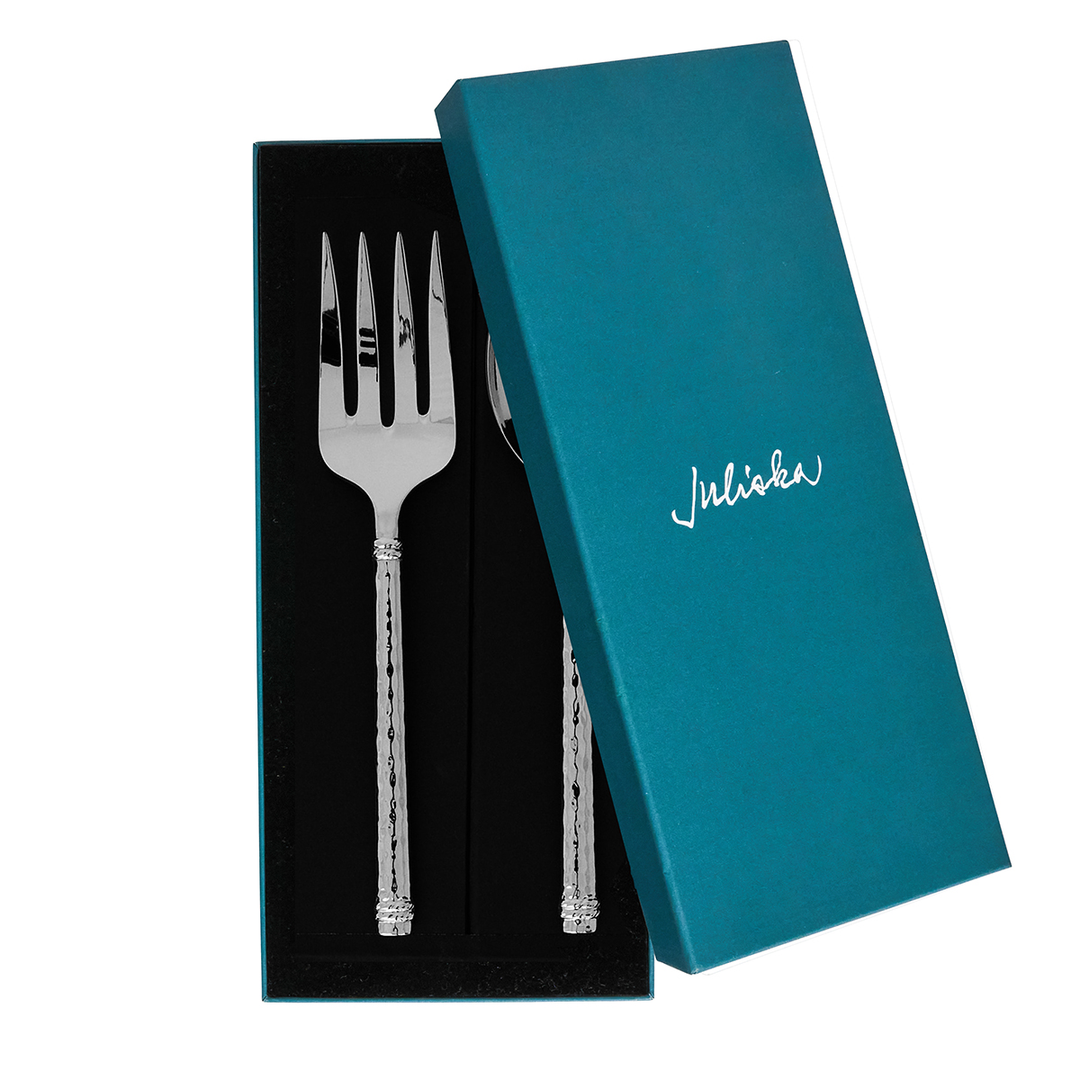 A silver hostess fork and spoon serving set in a partially opened blue box with Juliska packaging