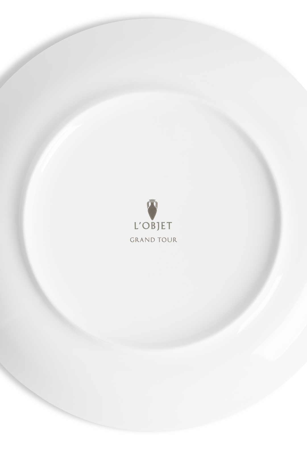 The white underside of a porcelain plate with the L'Objet logo and the words "grand Tour" inscribed