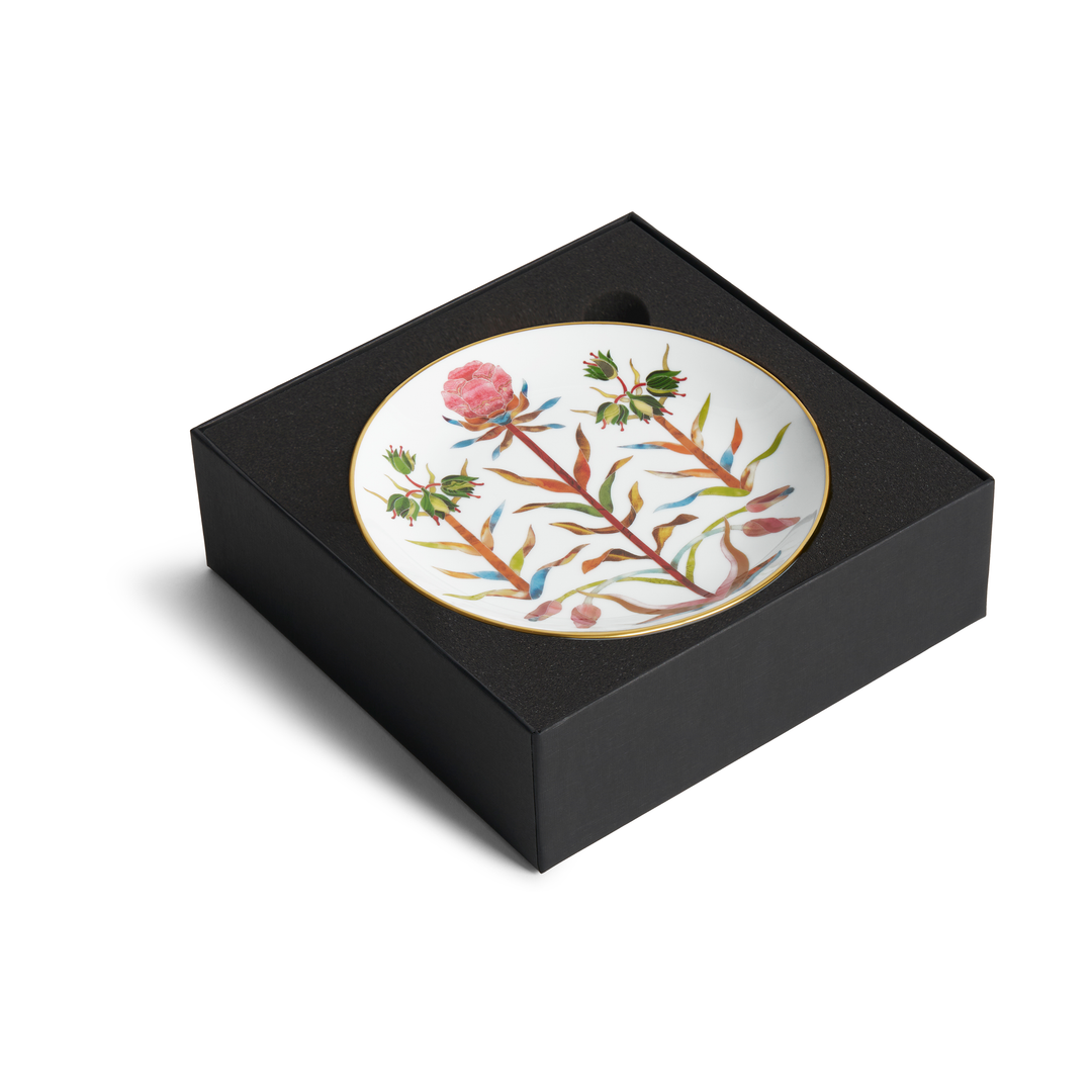A white dish with floral designs and a gold rim